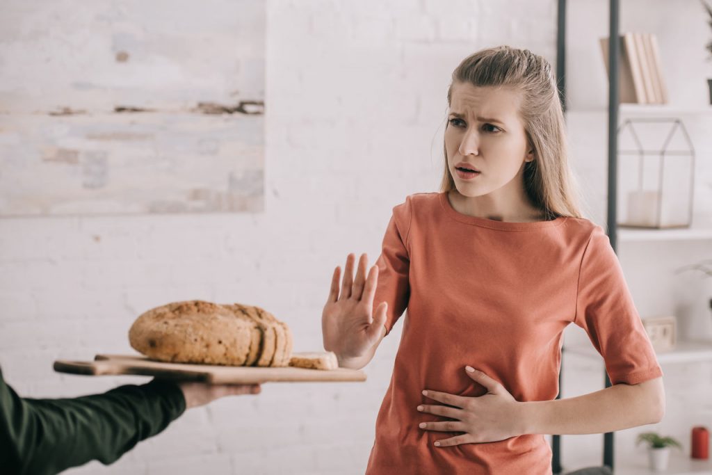 kobieta chorująca na celiakię odmawia zjedzenia chleba zawierającego gluten