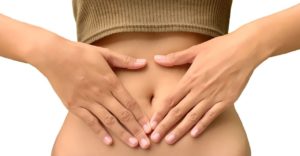 kobieta cierpiąca na wrzody żołądka trzyma się za brzuch