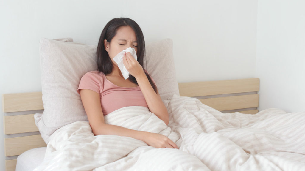 kobieta leżąca w łóżku z objawami alergii wziewnej
