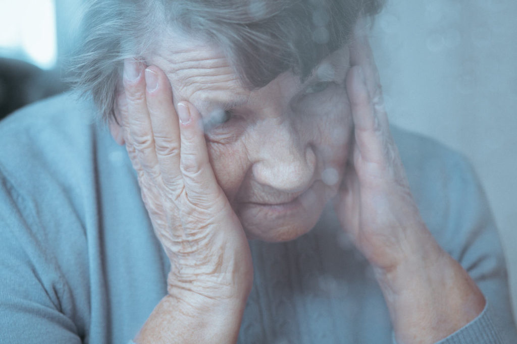 starsza kobieta mająca zawroty głowy spowodowane zapaleniem błędnika