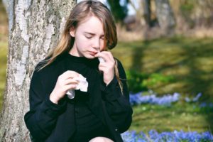 dziewczyna zmagająca się z alergią krzyżową stosuje leki na alergię